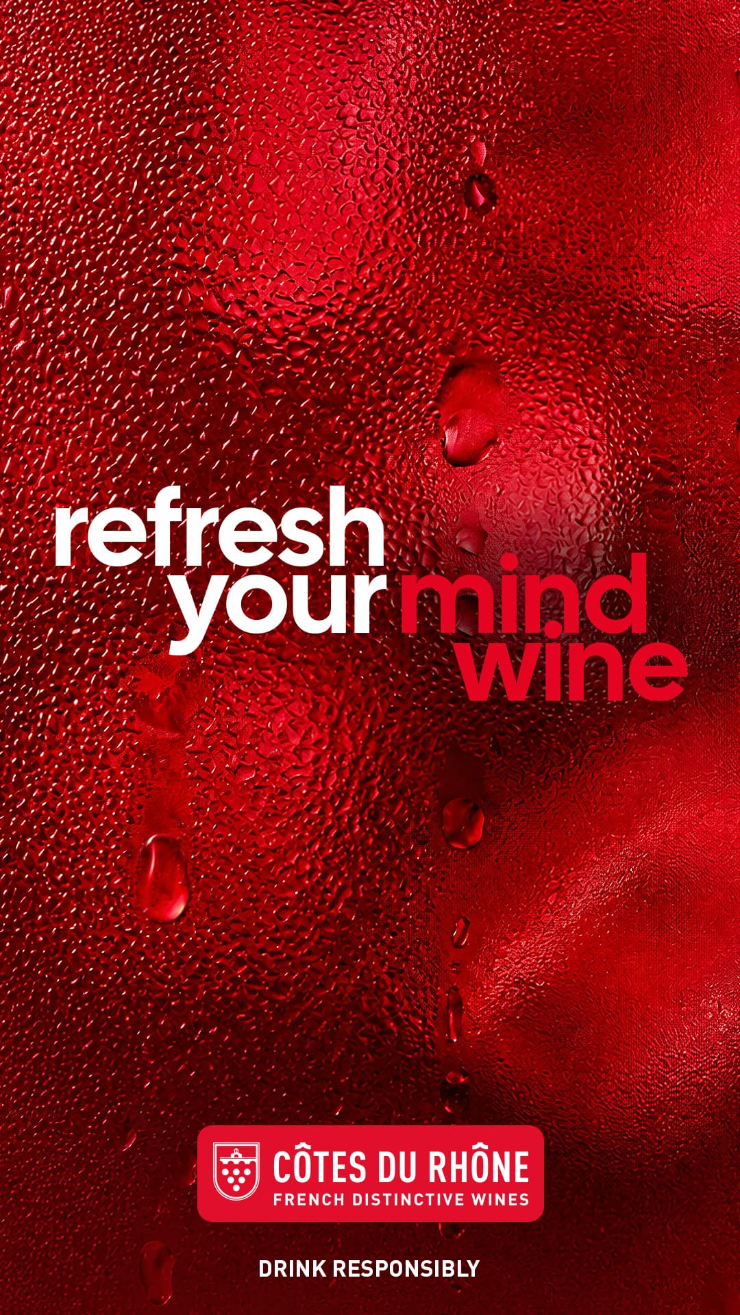Visuel print vertical format 1080x1920 de la campagne internationale Refresh your wine des Côtes du Rhône signée par l'agence Les Gros Mots déployée à partir du 6 juillet 2026, gros plan macro sur la paroi extérieure d'un verre de vin rouge intense couvert d'une buée dense et de gouttelettes d'eau glacée témoignant du service très frais, arrière-plan cadrage plein rouge grenat profond aux reflets sombres, accroche typographique en gros caractères sans serif à gauche du cadre refresh your mind wine en blanc et rouge vif, logo Côtes du Rhône French Distinctive Wines dans un pavé rouge en pied de visuel avec mention Drink Responsibly, esthétique publicitaire contemporaine sensorielle et graphique