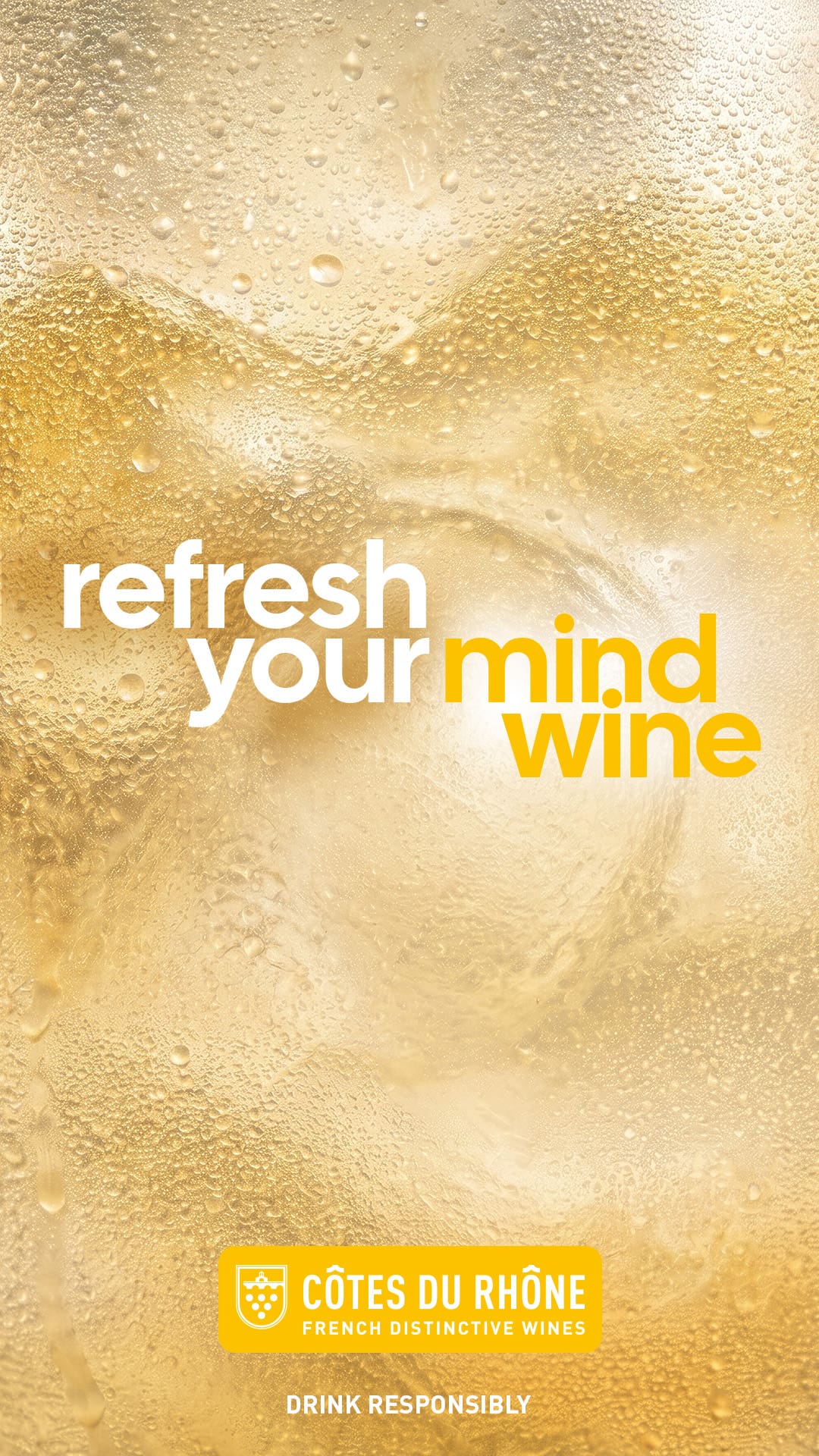 Deuxième visuel print vertical de la campagne Refresh your wine des Côtes du Rhône signée Les Gros Mots, déclinaison blanc format 1080x1920, gros plan macro sur la paroi extérieure d'un verre de vin blanc jaune paille aux reflets or, buée épaisse et bulles fines sur toute la surface témoignant d'un service très frais, arrière-plan jaune ocre chaud à zones plus claires suggérant la lumière solaire traversant le liquide, accroche typographique en gros caractères sans serif refresh your mind wine en blanc et jaune vif à gauche du cadre, logo Côtes du Rhône French Distinctive Wines dans un pavé jaune vif en pied de visuel avec mention Drink Responsibly
