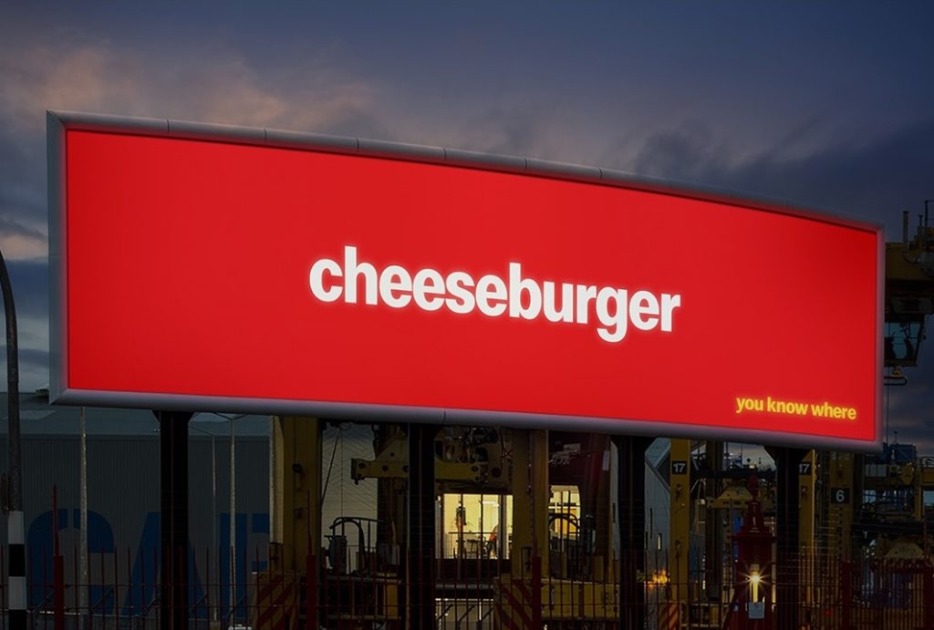 Affichage McDonald's New Zealand dévoilé à Catchy le 22 juin 2026, panneau publicitaire vertical d'arrêt de bus à Auckland avec uniquement les deux mots Big Mac en typographie noire en capitales sur fond jaune saturé