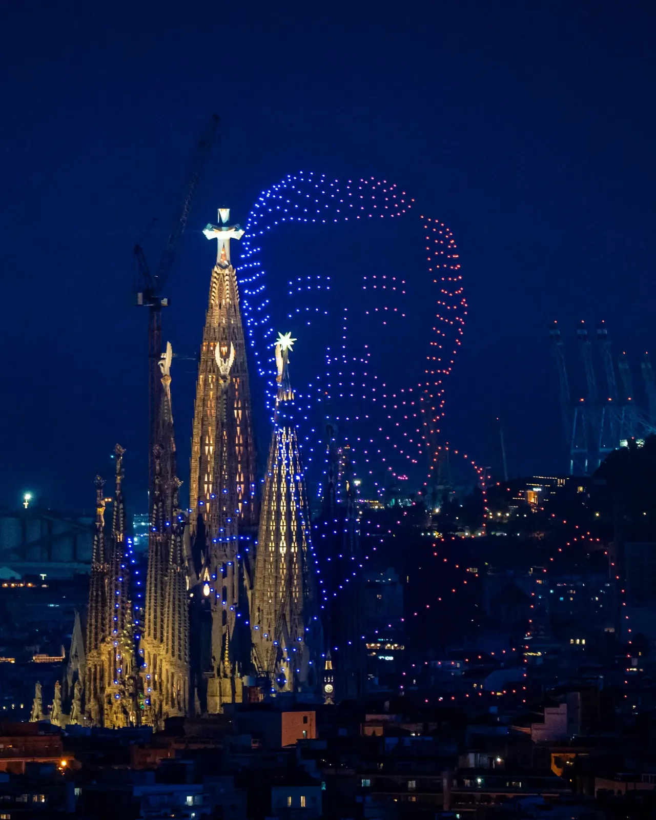 Spectacle de drones organisé le 13 juin 2026 au-dessus de la Sagrada Família à Barcelone pour le centenaire de la mort d'Antoni Gaudí, 700 drones assemblent le visage de profil de l'architecte catalan dans le ciel nocturne, en arrière-plan les flèches éclairées de la basilique encore en chantier et la tour de Jésus inaugurée le même jour à 172,5 mètres de hauteur
